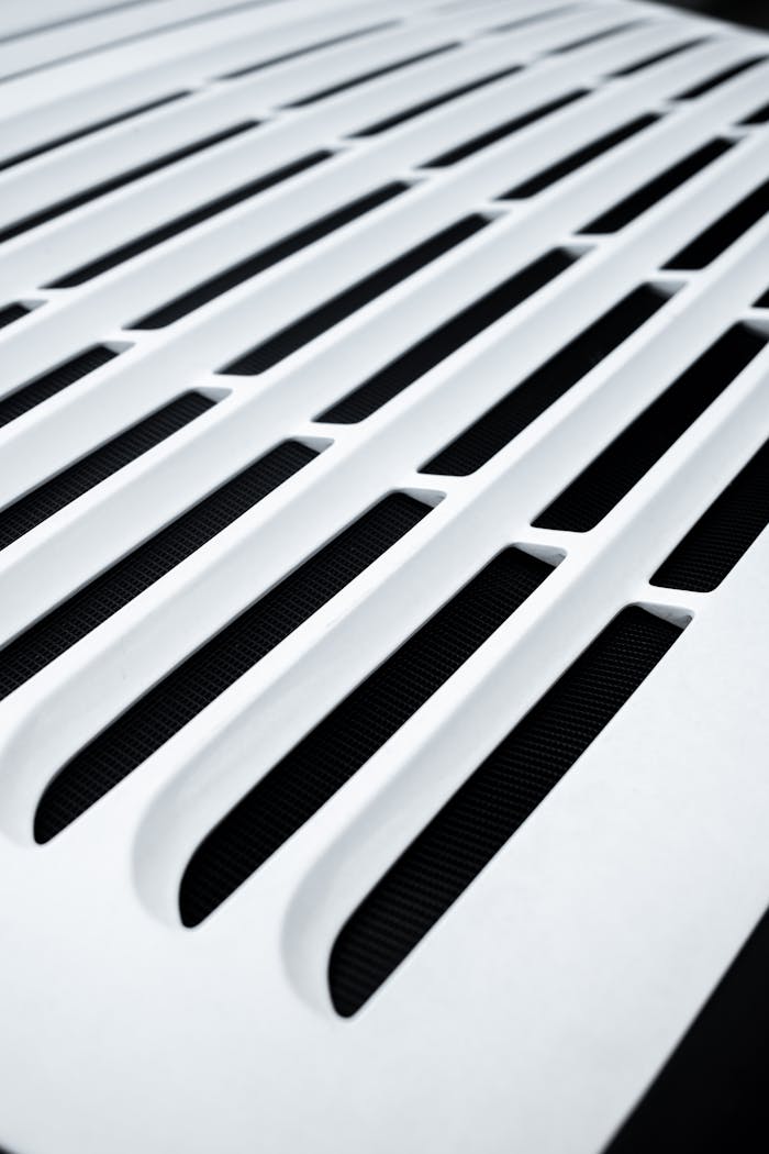 services-01 Close-up of a white vent with a modern pattern, highlighting sleek design elements.